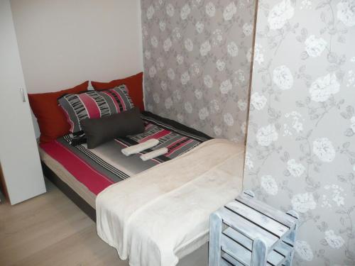 ブダペストにあるLaky9 Apartmanの小さなベッドルーム(ベッド1台、椅子付)