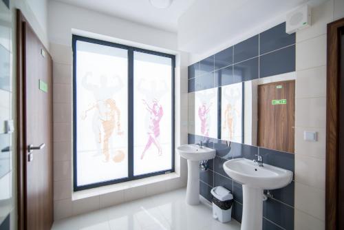 a bathroom with a sink and a window with a windowtaining at Dom Studenta AŁ in Łomża