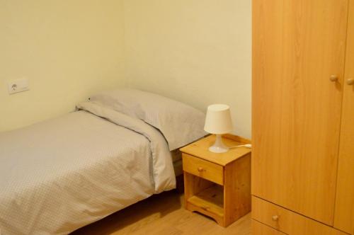una camera da letto con un letto e una lampada sul comodino di Peris Mencheta a Siviglia