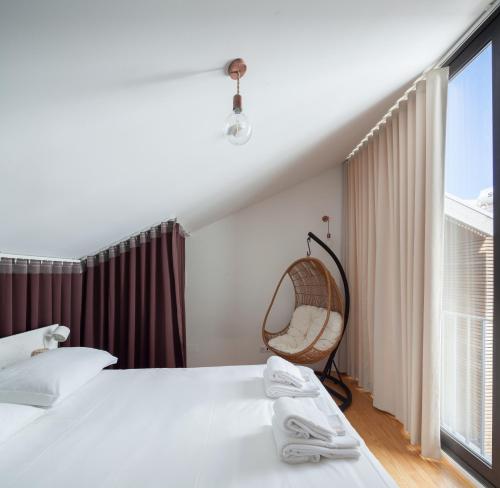 a bedroom with a bed and a chair and a window at 7 Gaia Roaster Apartments in Vila Nova de Gaia