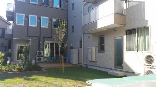 an apartment building with a yard in front of it at Tokyo Guest House 2020 in Tokyo
