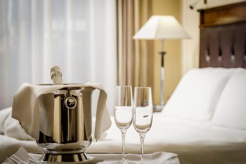 two wine glasses on a table in a hotel room at Eurostars Centrale Palace Hotel in Palermo