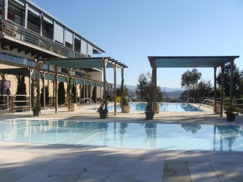 a pool at a hotel with a pavilion at Coimbra Camping & Bungalows in Coimbra