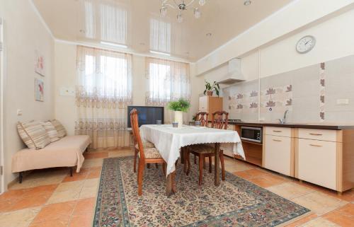 cocina con mesa, sillas y sofá en Guesthouse on Kyzyl-armeyskaya en Kazán