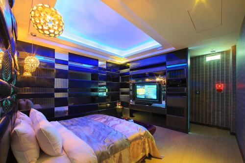 a bedroom with a bed and a television in it at Roman Vacation Motel in Dali