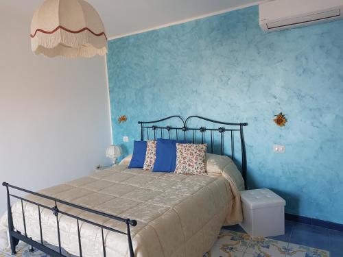 sypialnia z łóżkiem i niebieską ścianą w obiekcie B&B Oliva w mieście Scala