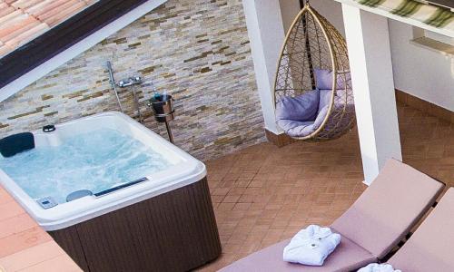 a tub in a room with a chair and a swing at Rooftop Apartment in Garda
