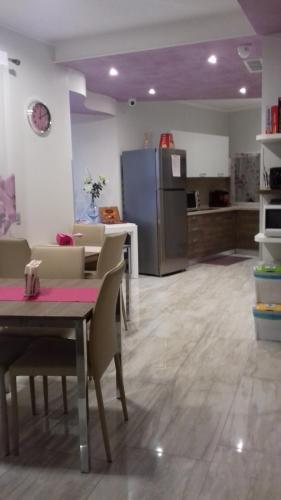 eine Küche mit einem Tisch und Stühlen sowie einem Kühlschrank in der Unterkunft B&B Tre passi CIR 23091 in Verona