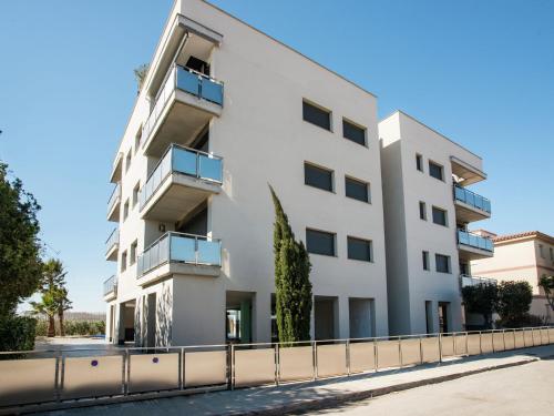 un edificio blanco con una valla delante en Belvilla by OYO Bon Relax Flat 2, en Sant Pere Pescador