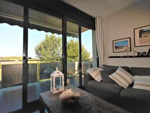 sala de estar con sofá y ventana grande en Belvilla by OYO Bon Relax Flat 2, en Sant Pere Pescador