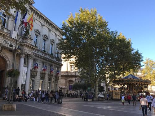 a group of people walking in front of a building at Les Coulisses de l'HORLOGE - WIFI - 50 m Palais des Papes in Avignon