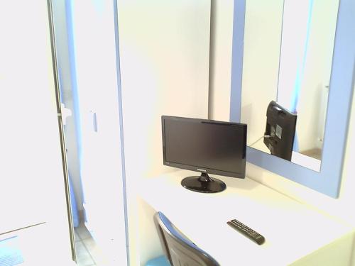 un monitor per computer seduto su una scrivania con specchio di Affittacamere Bellavista a Castiglione di Sicilia