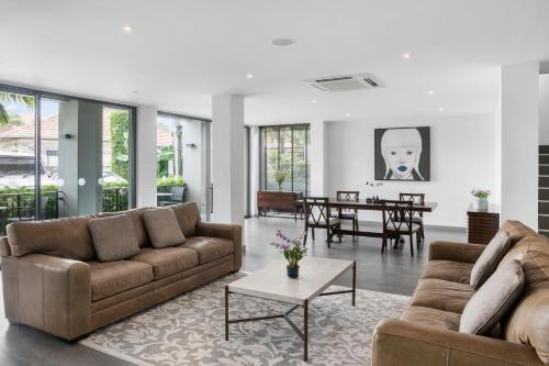 una sala de estar con 2 sofás marrones y una mesa. en The Sala Pattaya - SHA Certified, en Jomtien Beach