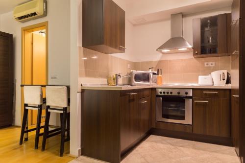 a kitchen with wooden cabinets and a stove top oven at Gozsdu Court Budapest in Budapest