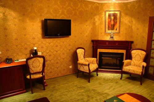 sala de estar con chimenea y TV en la pared en Oazis Hotel, en Saratov