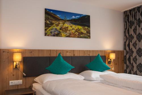 duas camas num quarto de hotel com almofadas verdes em Haus Sattelblick em Sankt Anton am Arlberg
