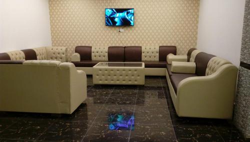 a waiting room with couches and a tv on a wall at Exotica Sampan in Cox's Bazar