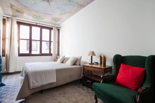 セビリアにあるAngeles Houseのベッドルーム1室(ベッド1台、緑の椅子付)