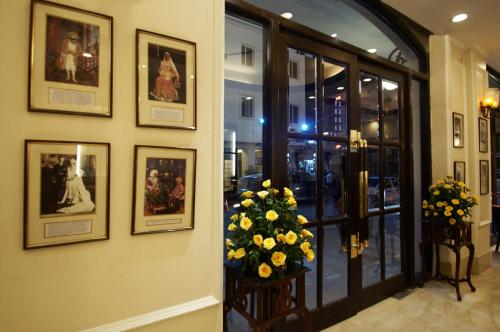 a hallway with a bunch of pictures on a wall at Hotel Ajanta - Colonial Charm Award Winning Luxury Hotel in the Heart of the City in New Delhi