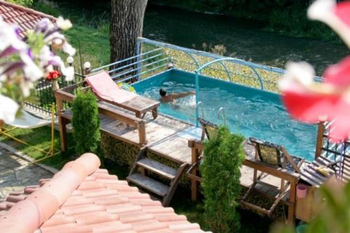 a swimming pool with a person in the water at Bilya Richky Hotel in Kamianets-Podilskyi