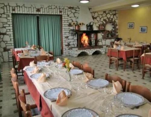 a dining room with a long table and a fireplace at Hotel El Senor in Pretoro