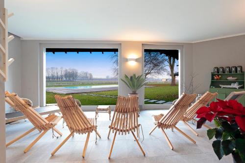 a group of chairs sitting in a room with windows at Agriturismo Tenuta "Il Cigno" in Villanterio
