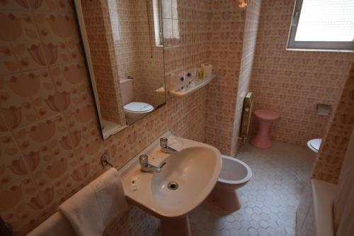 a bathroom with a sink and a toilet and a mirror at Hostal Blazquez Sanchez in Béjar
