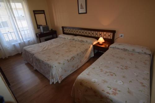 a hotel room with two beds and a window at Hostal Blazquez Sanchez in Béjar
