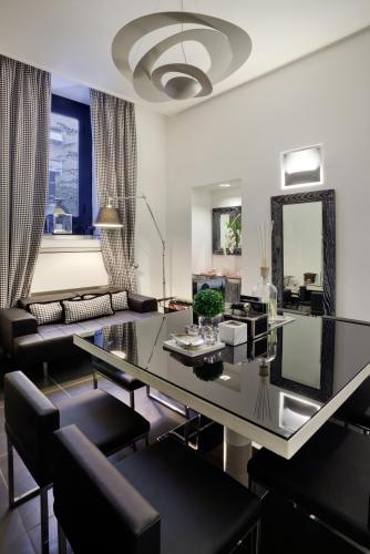 a living room with a glass table and chairs at LHP Hotel Napoleon in Milan