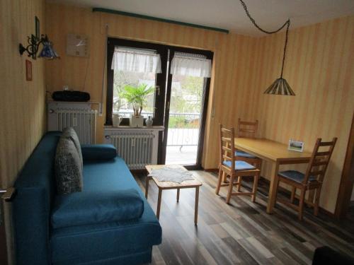 ein Wohnzimmer mit einem blauen Sofa und einem Tisch in der Unterkunft Fewo Gästezimmer in Ellenz-Poltersdorf