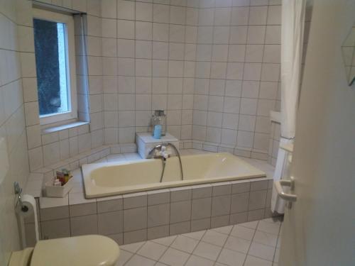 a bathroom with a bath tub and a sink at Oberhof in Bodman-Ludwigshafen