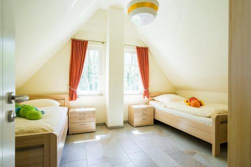 two beds in a room with two windows at Ferienhaus Rügensonne Glowe - Rügen in Glowe