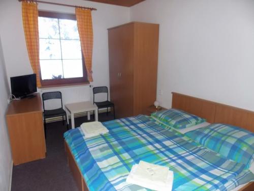 a bedroom with a bed and a table and chairs at Penzion u Hajneho Bedricha in Harrachov