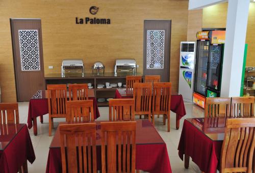 un ristorante con tavoli e sedie e un distributore di bibite di La Paloma Hotel Ninh Binh a Ninh Binh