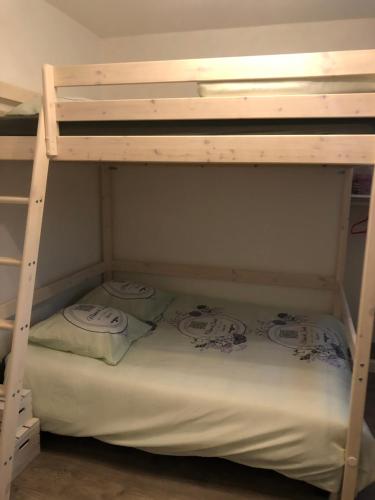 ユジーヌにあるAppartement tout confort Ugineの二段ベッドの下段に枕2つが備わります。