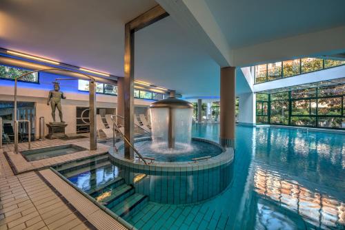 una gran piscina con una fuente en un edificio en Hotel Terme Olympia, en Montegrotto Terme