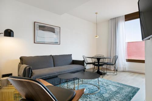 a living room with a couch and a table at Vale Suites in Barcelona
