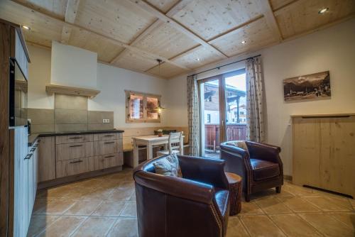 a kitchen with two chairs and a table in it at Apartments Landhaus Sonnheim in Lofer