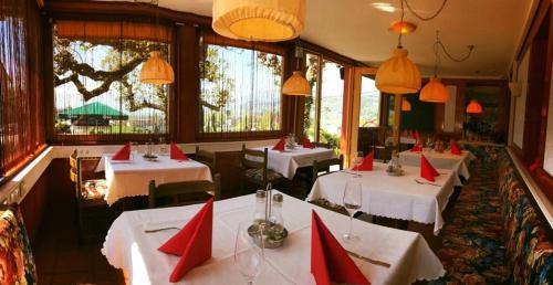 un restaurante con cuatro mesas con servilletas rojas. en Gasthaus Tisis, en Feldkirch