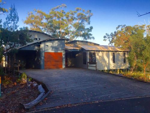 a house with a driveway in front of it at The Holiday House in K'gari Island (Fraser Island)