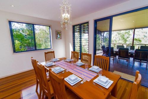 comedor con mesa de madera y sillas en The Holiday House, en Fraser Island