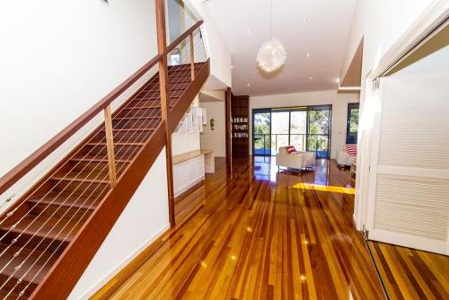 a living room with a staircase in a house at The Holiday House in K'gari Island (Fraser Island)