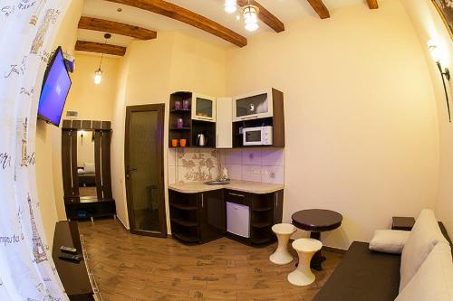 Cette chambre dispose d'une cuisine avec un comptoir et une table. dans l'établissement Віп квартира вулиця Куліша 13 біля Форуму недалеко Малевичу, à Lviv