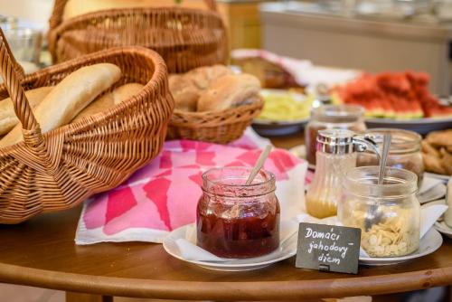 a table with bread and jam and baskets of food at Hotel Villa Siesta in Smokovce