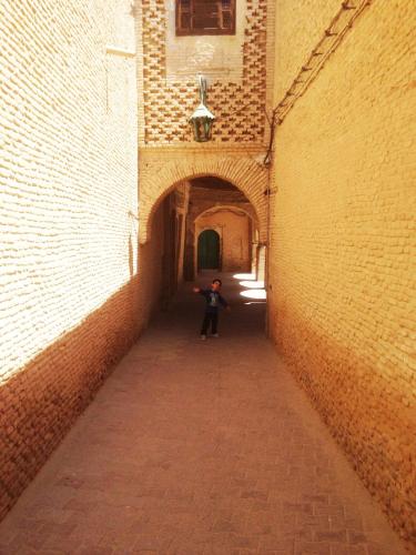 a person is standing in an alley way at Dar Ezzahra in Tozeur