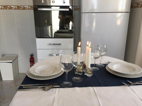 una mesa con platos, copas de vino y velas en Dar Ezzahra, en Tozeur