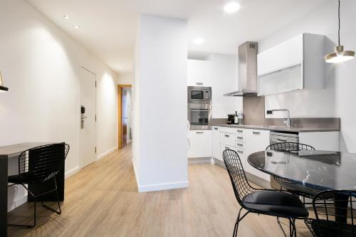a kitchen with a table and chairs and a dining room at Vale Suites in Barcelona