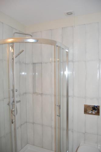 a shower with a glass door in a bathroom at Pokoje Nad Arkadami in Zamość