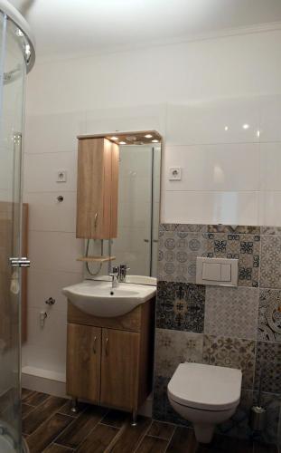 a bathroom with a sink and a toilet and a shower at VATUS Apartmanház Vác in Vác