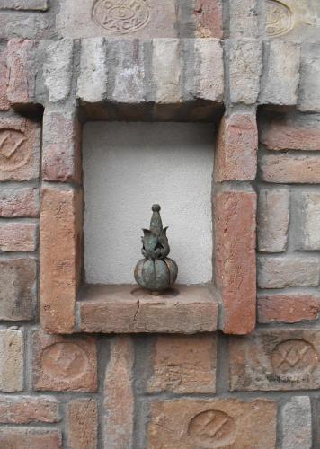a statue of two cats sitting on a ledge in a brick wall at VATUS Apartmanház Vác in Vác